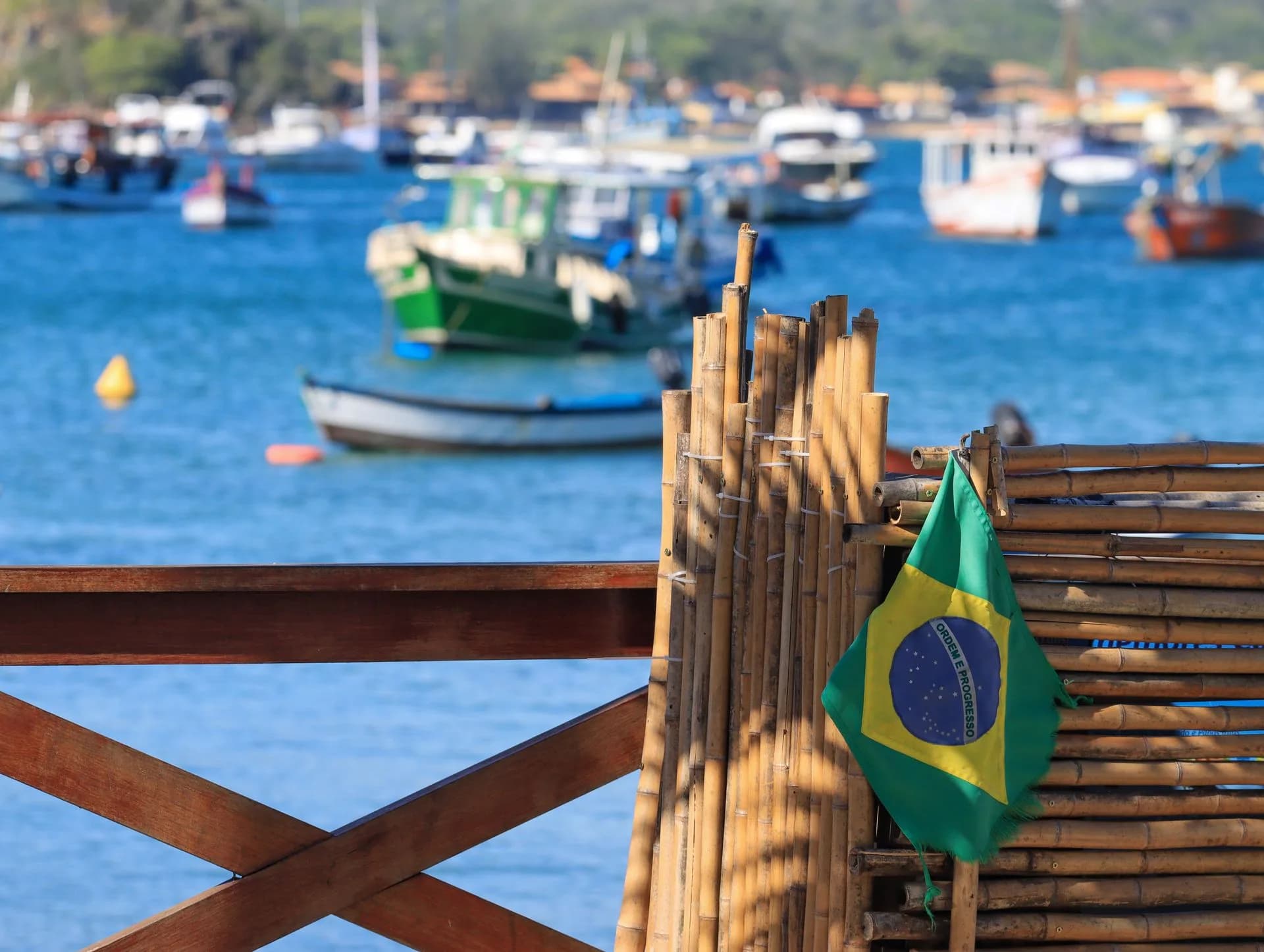 Brazilian flag above boats in a coastal bay, Brazil