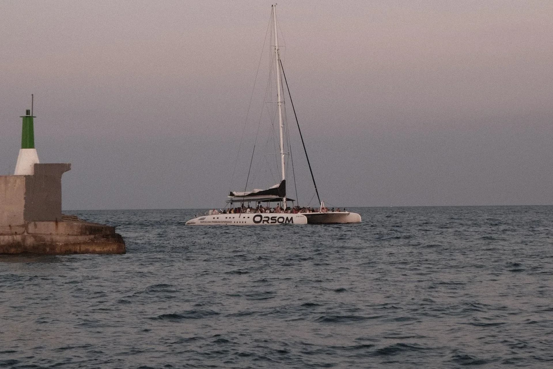 Sailboat on calm water at sunset in Barcelona, Spain