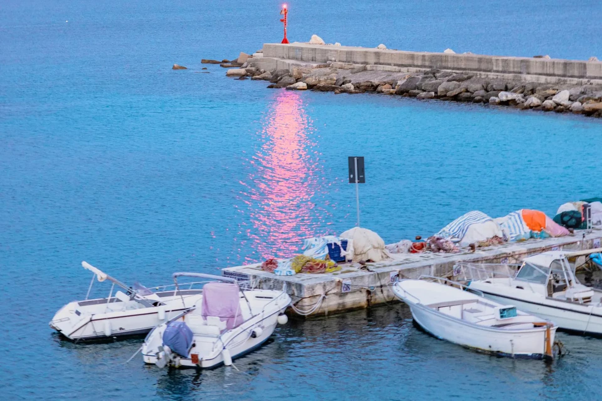 Boats moored at sunset in Gallipoli harbor, Italy