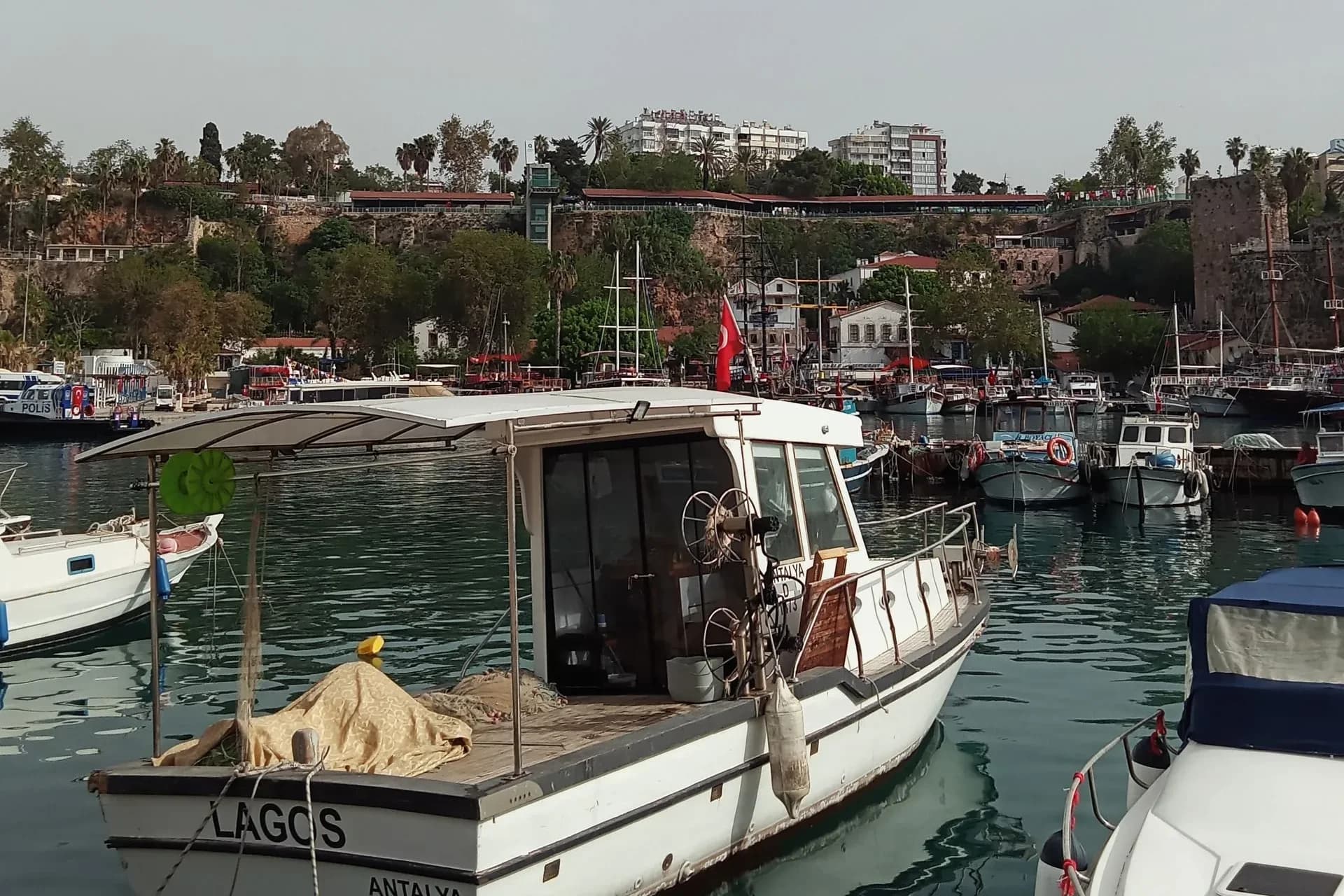 Moored boats and old waterfront buildings in Antalya harbor, Türkiye