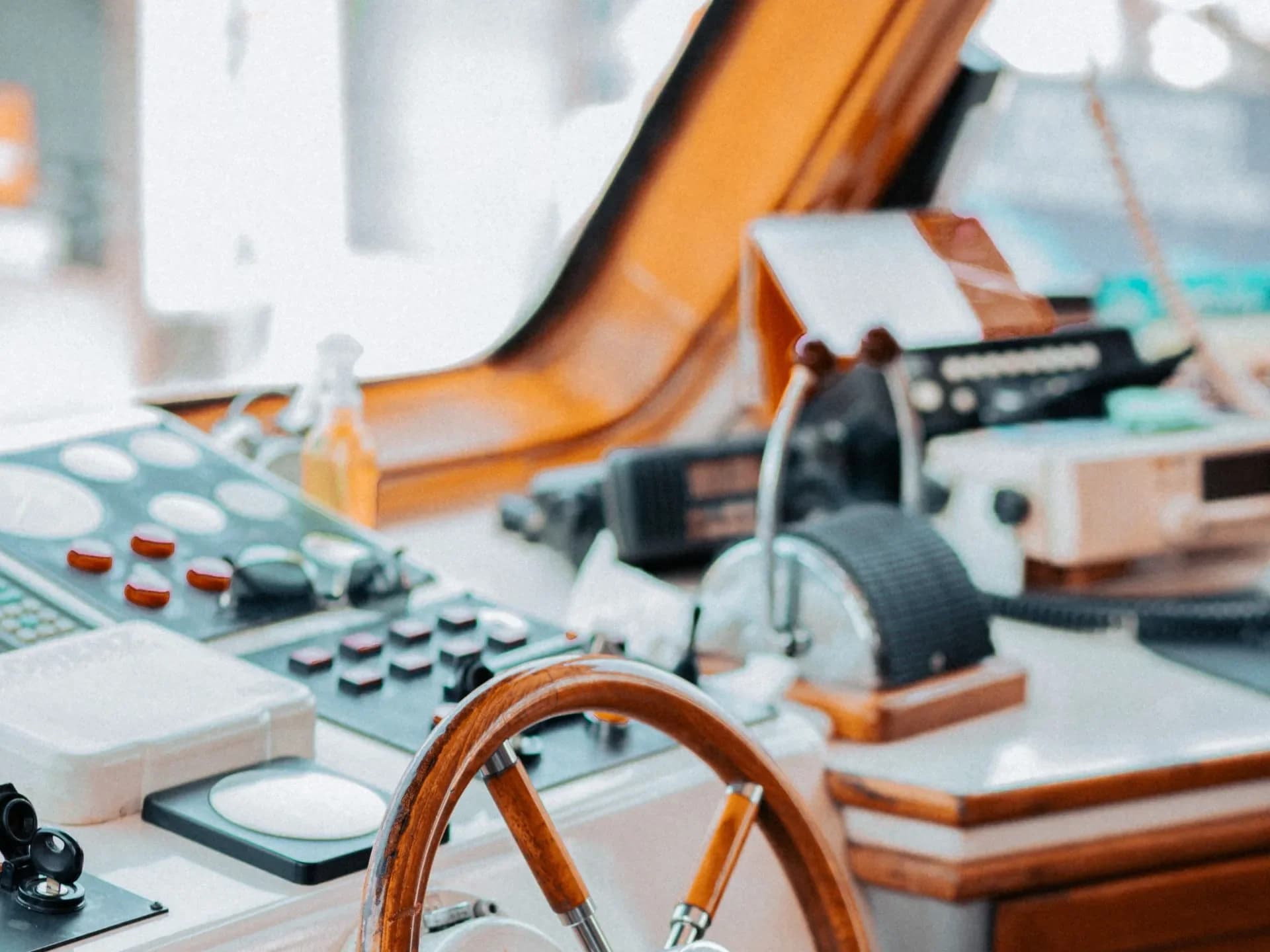 A wooden boat steering wheel and instrument console.