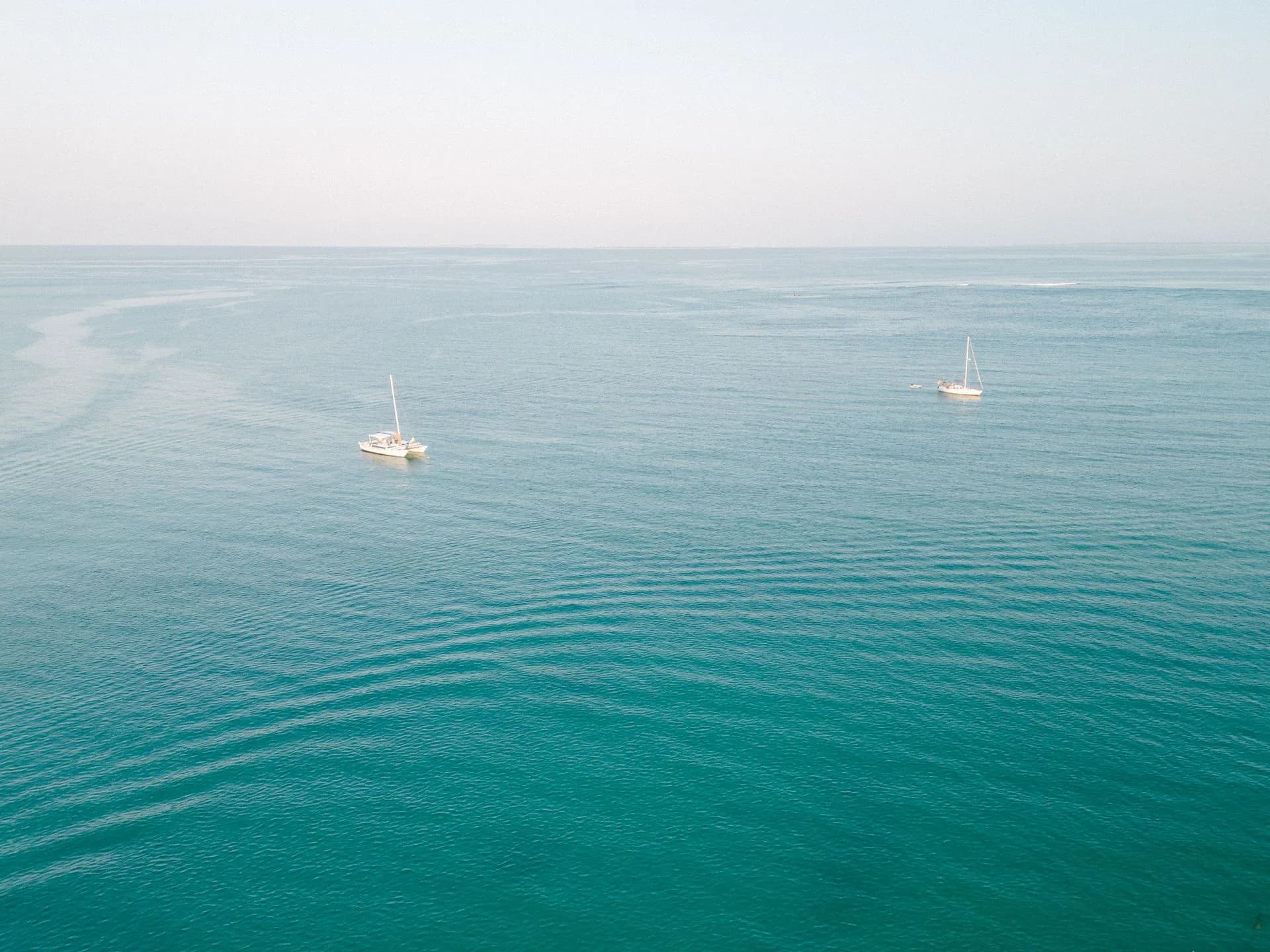 Aerial view of sailing boats on open water.