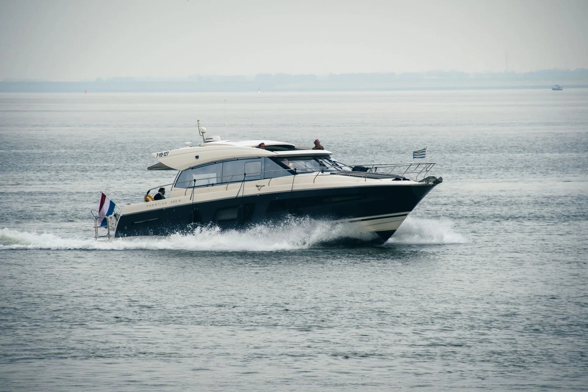 A white speedboat cruising over calm water.
