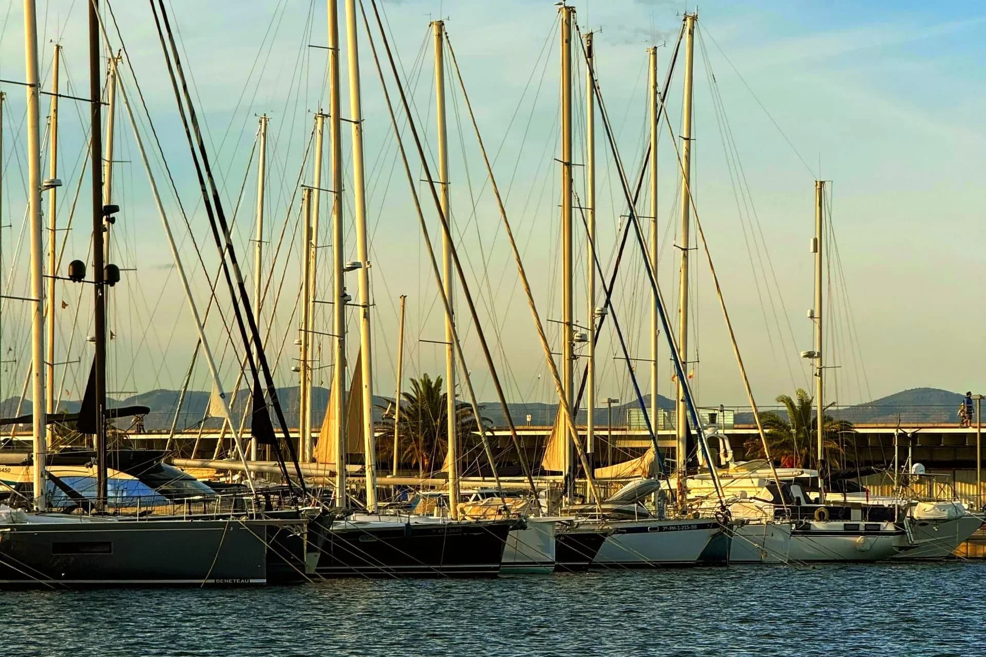 Sailboats docked at Valencia harbor under a blue sky, Spain