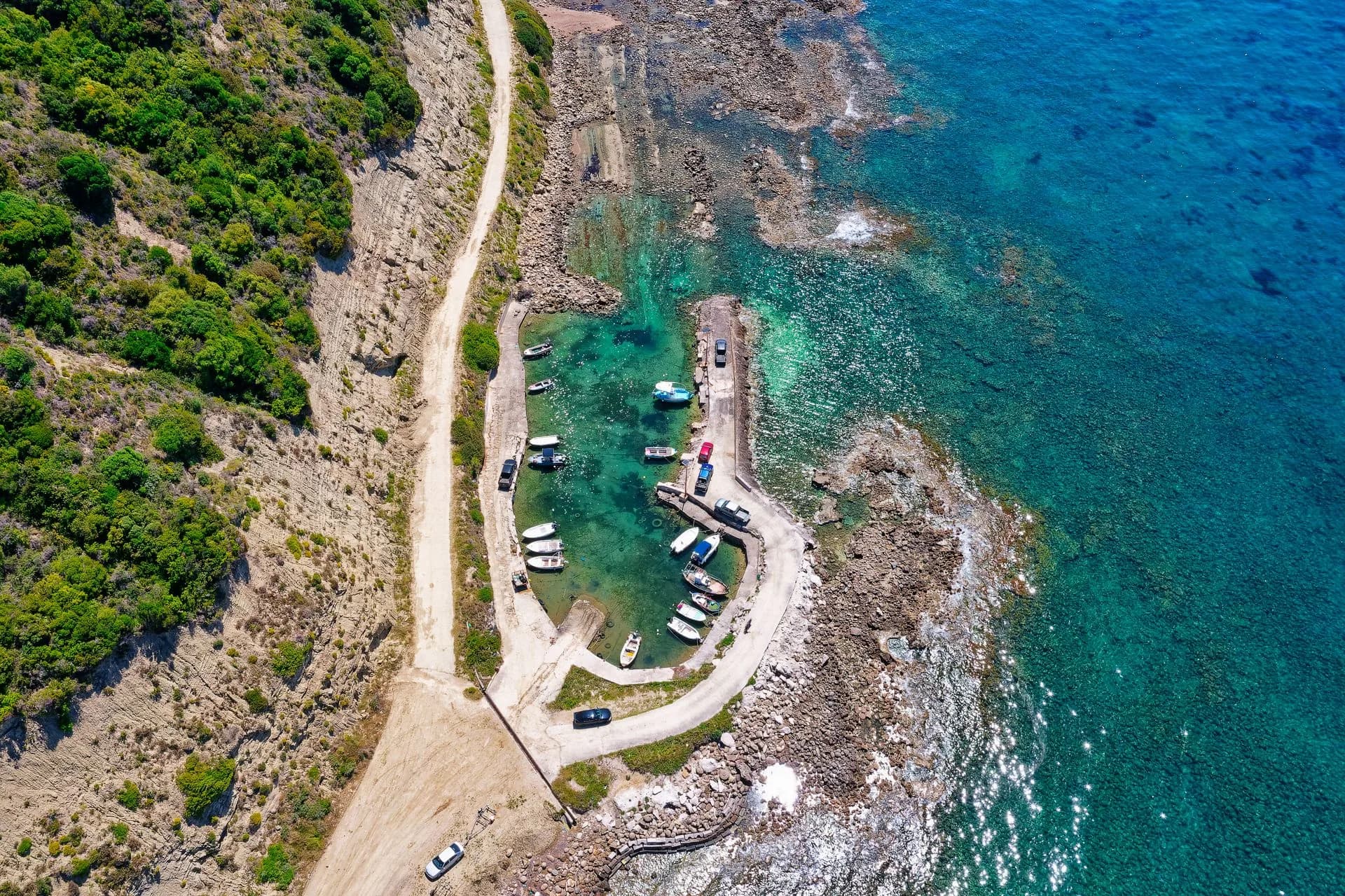 Anchored boats and rocky coastline by Kerkira, Greece