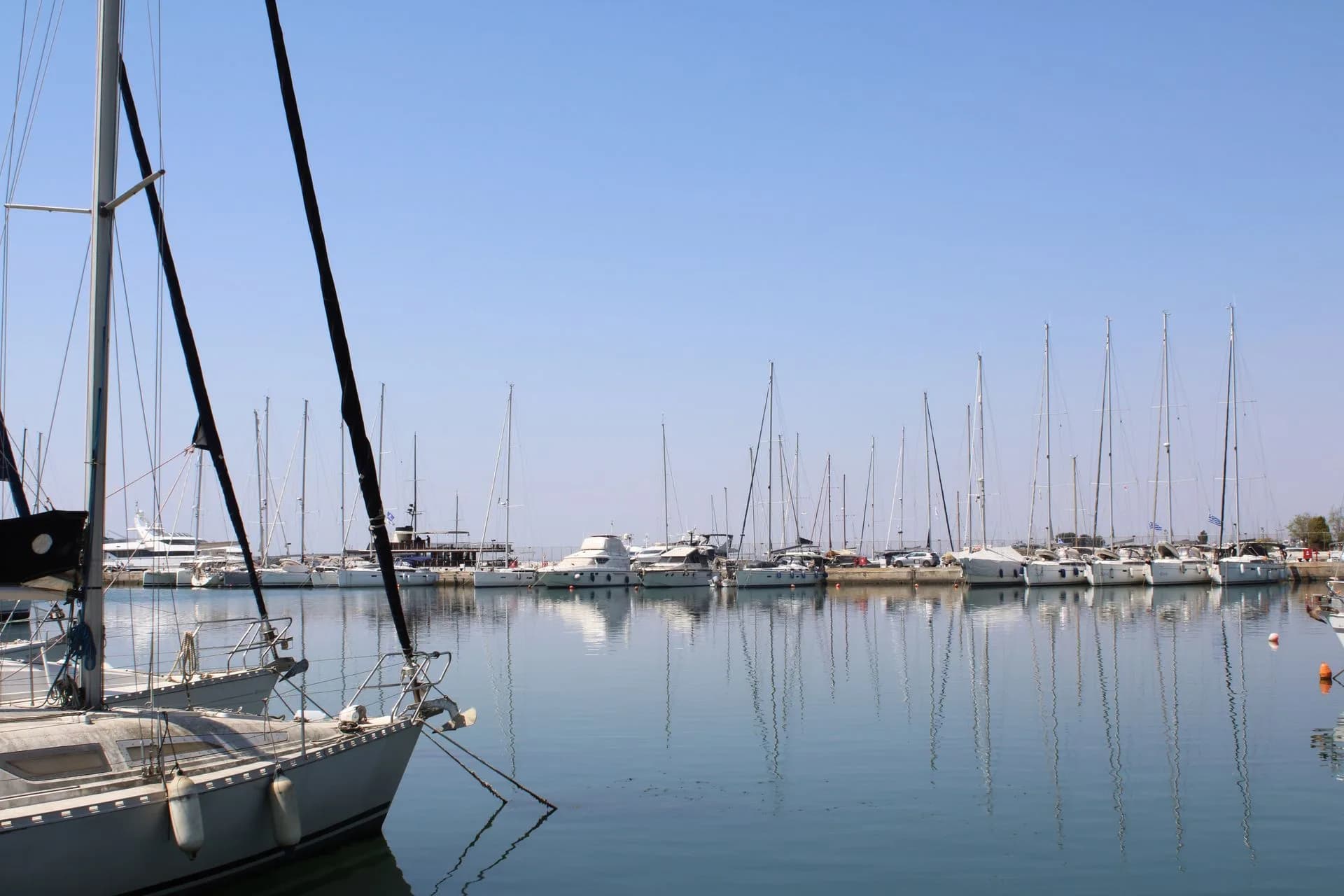 Sailboats docked under a blue sky in Thessaloniki, Greece