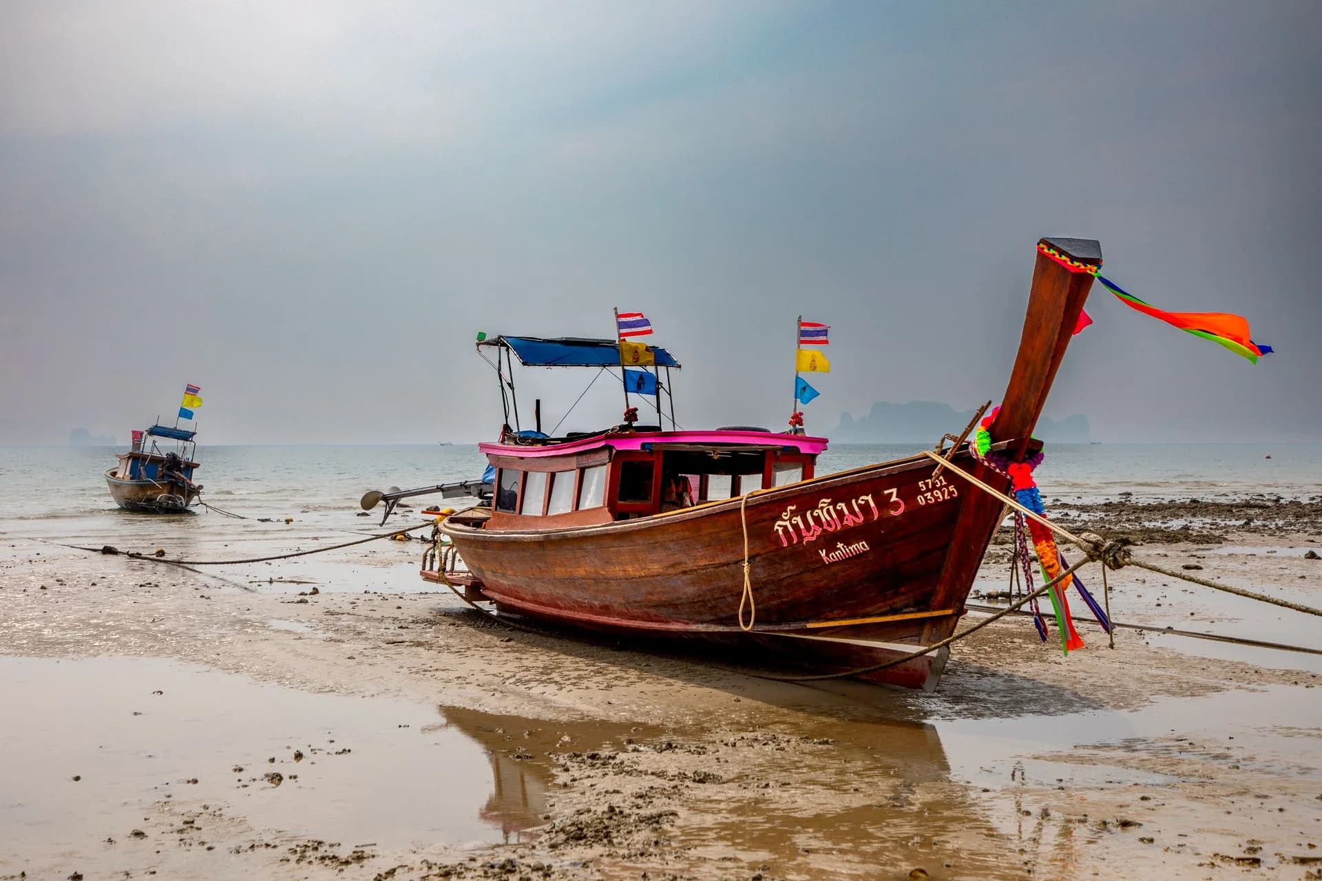 Traditional longtail boats on a beach in Krabi, Thailand