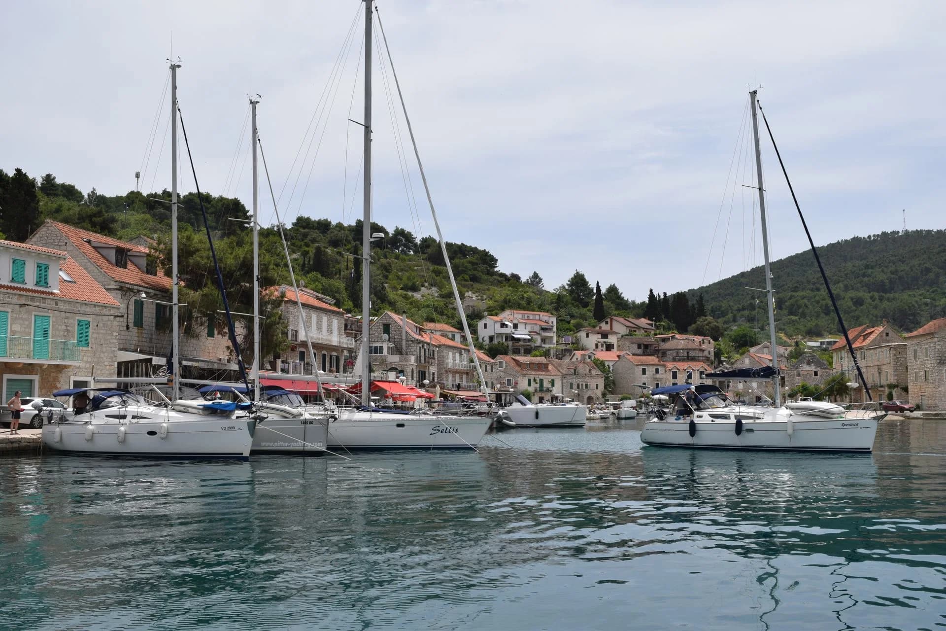 Sailboats anchored by waterfront houses in Hvar, Croatia
