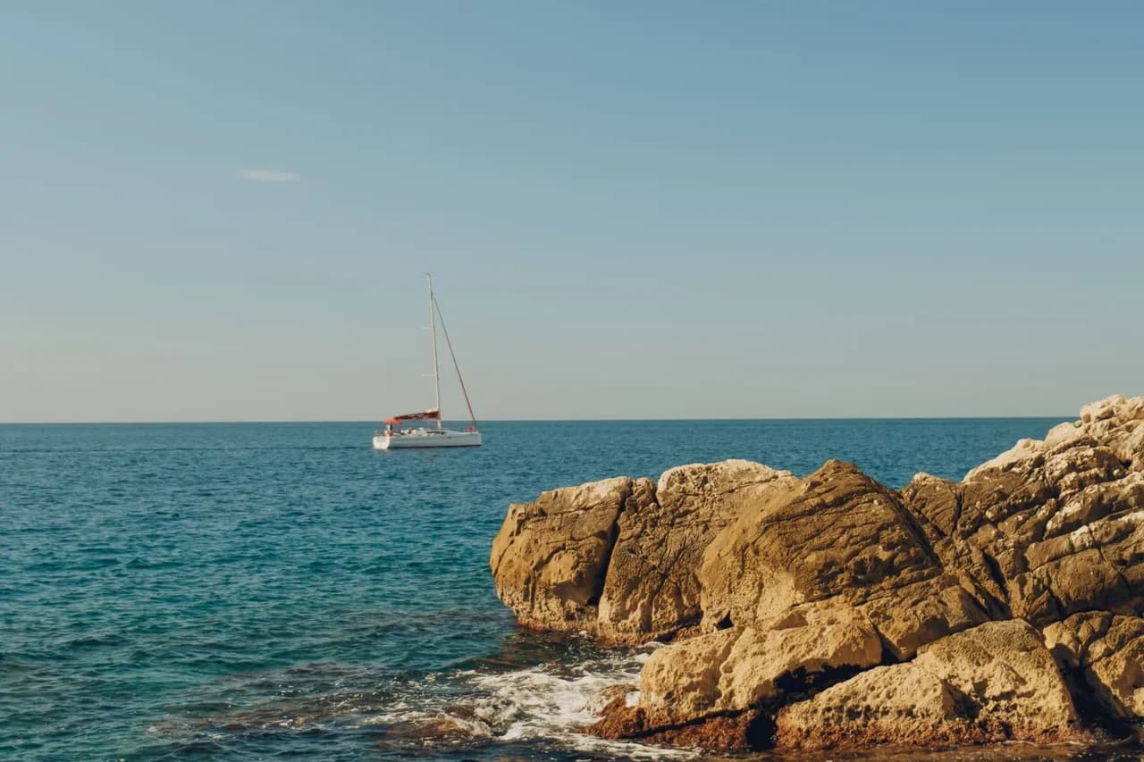 Boat beside the rocky Adriatic coastline of Dubrovnik, Croatia