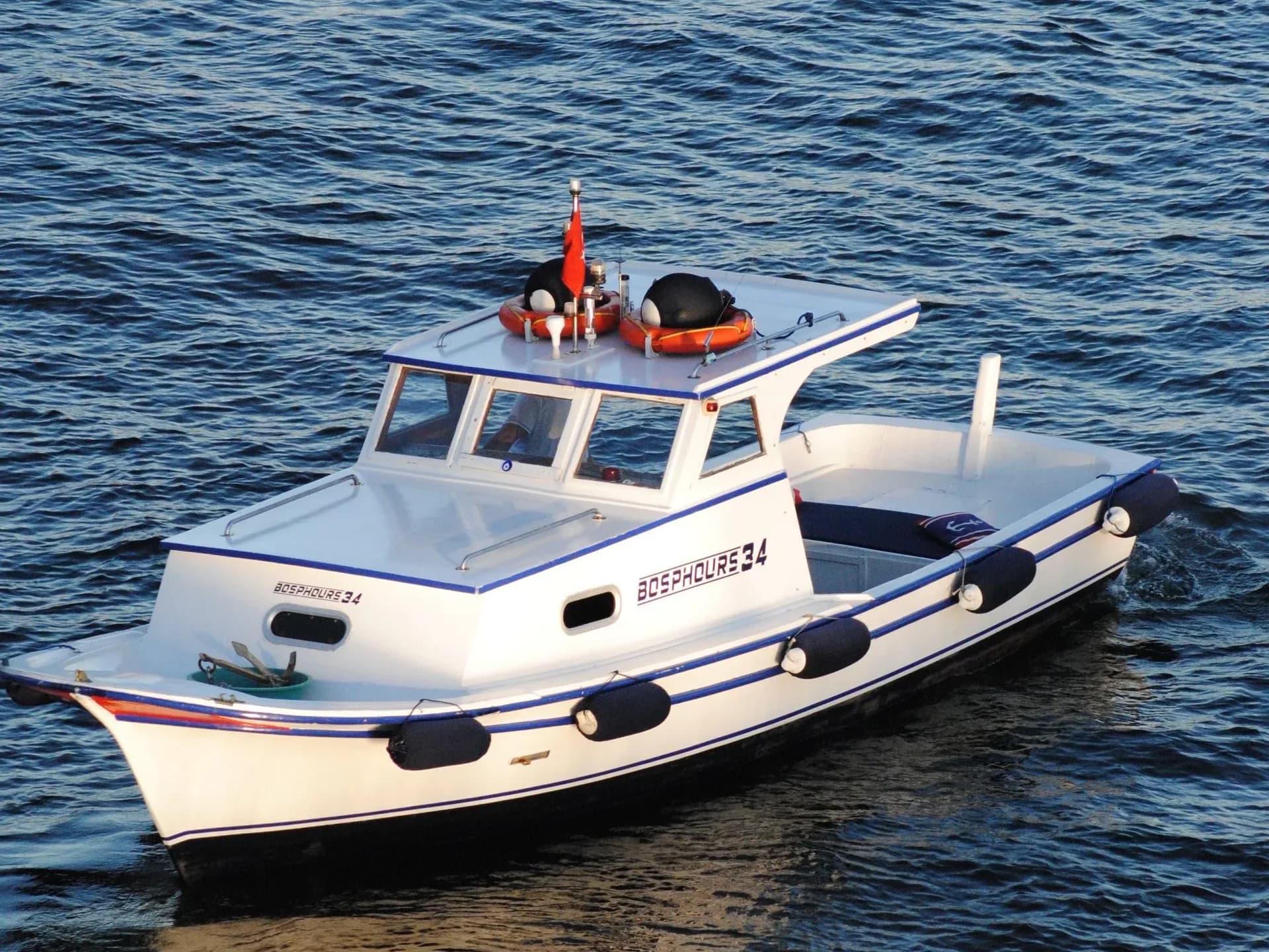 A white motorboat travelling over blue water.
