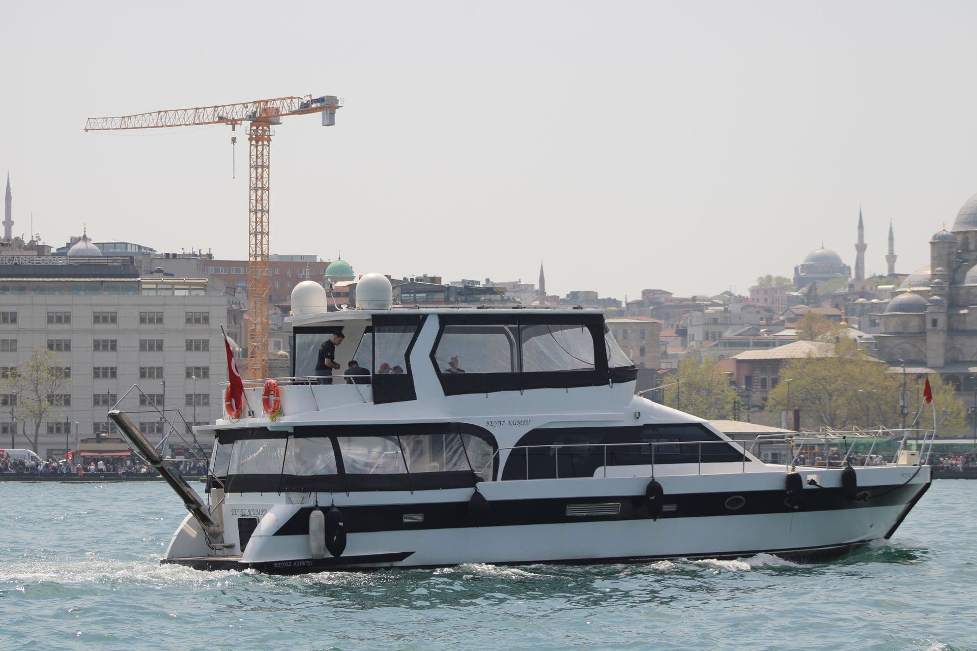 White motor yacht on the Bosphorus with Istanbul in the background